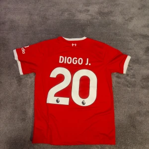 Liverpool FC | 23/24 | Size: M | Hemmatröja | Jota | Ny, oanvänd - Liverpools Hemmatröja för säsongen 2023-2024. Diogo J, nr 20 på ryggen. Helt ny & oanvänd. Stadium/fan edition. Storlek medium. Tröjan är en nyproducerad reprint i utmärkt kvalitet.  Skickas 1-3 dagar efter mottagen betalning. Har du frågor/funderingar är det bara att höra av dig! :)