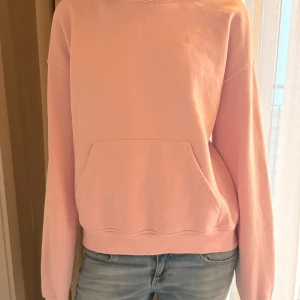 Rosa hoodie med ficka - Säljer en mysig rosa hoodie med en stor ficka framtill. Perfekt för en avslappnad stil och passar bra till jeans. Tröjan har långa ärmar och en klassisk design storlek S🥰🙌❤️