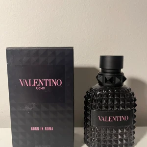 Valentino Uomo Born in Roma Eau de Toilette - Säljer en elegant flaska Valentino Uomo Born in Roma Eau de Toilette. Flaskan har en lyxig design med svart, nitat mönster och rosa text. Perfekt för sommar,vinter för dig som vill få alla brudar ! 