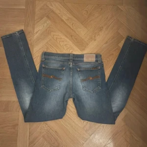 Blå jeans från Nudie Jeans - Snygga blå jeans från Nudie Jeans. De har en straight passform och är tillverkade i slitstarkt denim. Perfekta för en avslappnad stil. Model tight long john.