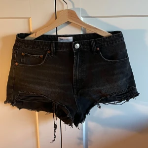 Svarta jeansshorts  - Snygga svarta jeansshorts från Zara med fransiga kanter. Storlek 40 men är liten i storleken! Supersnygga och sköna
