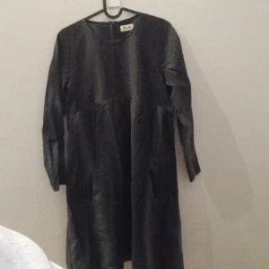 Svart klänning från Baum und Pferdgarten - Snygg svart grå klänning från Baum und Pferdgarten med diskret randigt mönster. Klänningen har långa ärmar och en dragkedja i ryggen. Perfekt för en stilren look.Den har fickor! Köpt second hand, har själv bara provat