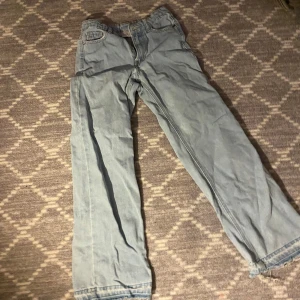 Ljusblå jeans från UNIQ Denim Wear - Säljer ett par ljusblå jeans från UNIQ Denim Wear. De har en klassisk design med raka ben och femficksmodell. Perfekta för en avslappnad stil.