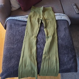 Gröna byxor från Lindex - Snygga gröna byxor från Lindex i en skön och stretchig passform. Byxorna har en hög midja och raka ben, vilket ger en stilren look. Perfekta för en avslappnad men ändå chic stil.