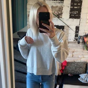 Grå tröja - Säljer en stilren grå tröja med rund hals och långa ärmar. Tröjan har ribbade muddar vid ärmslut och nederkant, vilket ger en snygg passform. Perfekt för en avslappnad look.