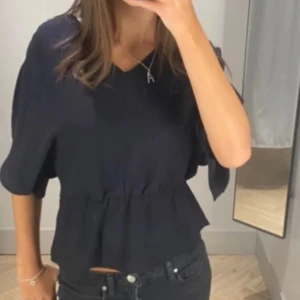 Svart v-ringad topp - Snygg svart v-ringad topp med korta ärmar som är lite figur sydd i midjan 💕