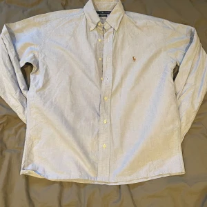 Ljusblå Ralph Lauren skjorta  - Skjorta från Ralph Lauren i storlek 16-35 vilket ungefär motsvarar storlek L (kan skicka mått vid frågan). Skicket är mycket bra och nypris ligger på 1599.