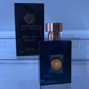 Versace Dylan Blue Pour Homme - Tjena, pris går att diskutera vid snabb affär.     Säljer en elegant Versace Dylan Blue Pour Homme parfym i en stilren mörkblå flaska med guldiga detaljer. Flaskan rymmer 50 ml endast 15ml kvar och har en lyxig känsla med en rund guldmedaljong på framsidan. Perfekt för den som vill ha en sofistikerad doft.