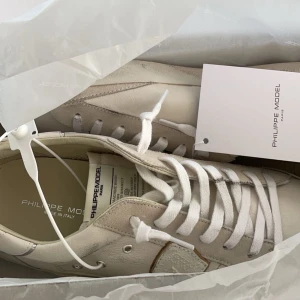 Philippe Model vita sneakers - Säljer ett par snygga vita Philippe Model sneakers. De har en ren design och ärperfekta för både vardag och fest. Det slitna som synns på skorna är en del av designen och du kan gärna kolla upp det om det är osäkert! Skorna är i okej skick kring 8/10 och putsar dem så gott det går före köpet. Skorna kommer i originalboxen. Köpt originellt från FRMODA för 328€/3800 kr. Kom gärna och hör av dig om det finns fler frågor!