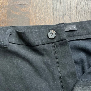 Svarta kostymbyxor med diskreta ränder - Snygga svarta kostymbyxor i damstorlek S med diskreta ränder. Mid waist, perfekt till jobb eller skola 