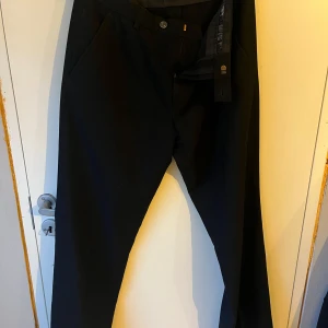 Kostymbyxor - Svarta kostymbyxor i storlek 148 (ca M/L?). Ganska tjockt material och har sytt upp dem (går att sprätta upp enkelt) 
