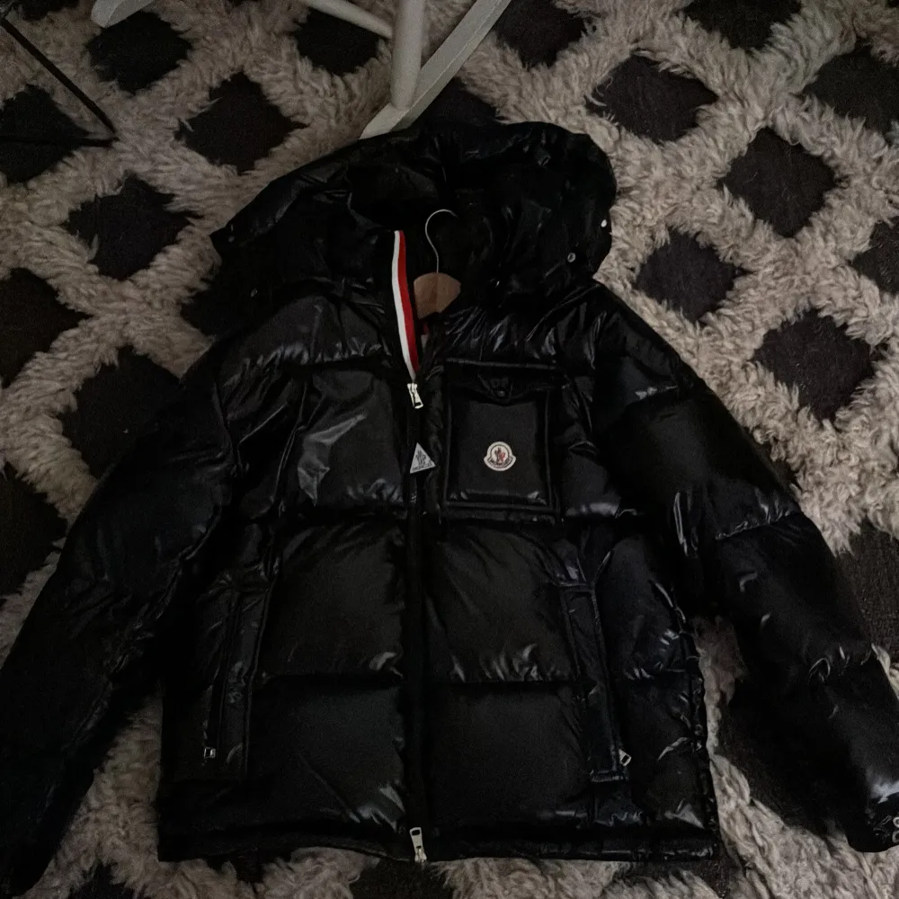 Säljer en snygg svart pufferjacka från Moncler. Den är i mycket bra skick och perfekt för vintern. Jackan har en dragkedja och en cool broderad Moncler-logga på bröstet. Den är långärmad och har en quiltad design som håller dig varm. Perfekt för både vardag och fest!. Jackor.