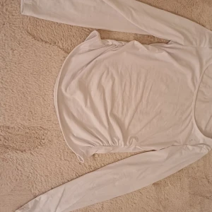 Vit långärmad tröja - Säljer en enkel och stilren vit långärmad tröja. Perfekt för lager-på-lager under höst och vinter. Tröjan är i bra skick och passar till alla tillfällen. Ett måste i garderoben för den som gillar klassiska basplagg.