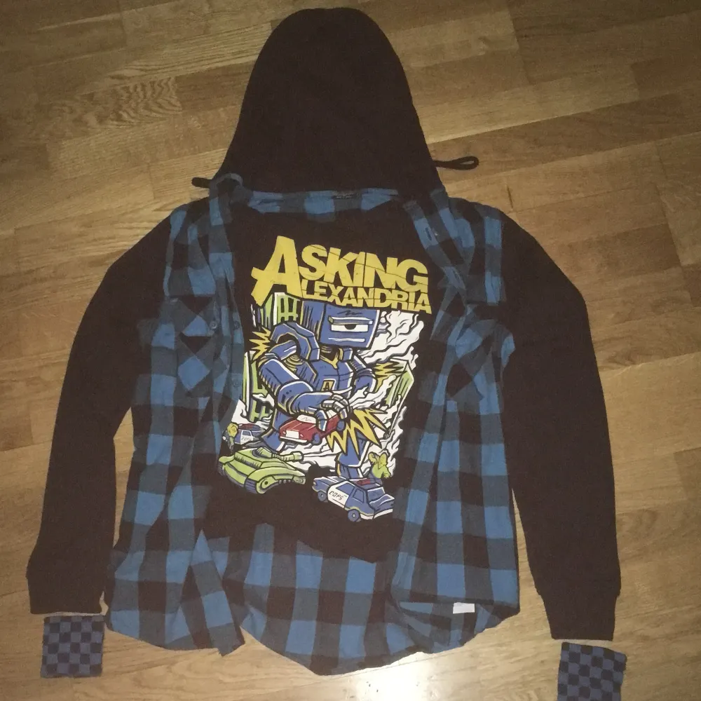 Använt bara några gånger när jag var 16. Säljer en cool svart hoodie med blå rutig skjorta och ruttiga sweatbands. Det är en vintage tröja från (2008-2009) av bandet Asking Alexandria. Perfekt för fans av bandet och för en 2000s Emo/Scene stil. Hoodien har långa ärmar och är i bra skick. Storlek medium (m) men funkar som Small (s). Säljer inte online eller skickar möts upp endast i Stockholm, Enskede och vid platan. . Tröjor & Koftor.