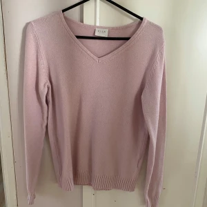 Ljusrosa tröja från VILA - Säljer en superfin ljusrosa tröja från VILA i storlek S. Den är stickad och har en snygg v-ringning. Perfekt för både vår och höst! Tröjan har långa ärmar och ribbade kanter som ger en stilren look. Passar både till vardags och lite finare tillfällen. 🌸