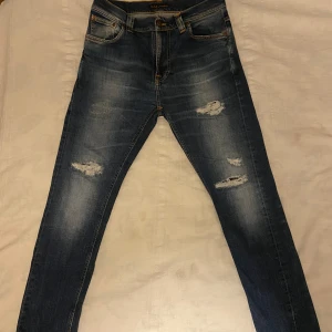 Nudie Jeans - Säljer ett par tvärfeta Nudies i storlek 29/30. INGA TECKEN PÅ ANVÄNDNING, modellen Brute Knut. Snygga slitningar på benen som inte går igenom tyget. Skriv vid frågor/funderingar🤙