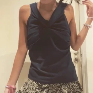 Mörkblå ärmlös topp💙 - Snygg mörkblå ärmlös topp med en unik twistad detalj framtill. Perfekt för en utekväll samt/eller fest. Toppen har en elegant och stilren design som passar till många olika outfits. Man kan ha på sig den på två olika sätt 💙💙