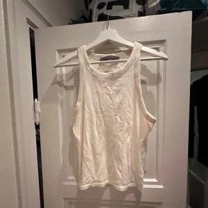 Vitt linne - Säljer en enkel och stilren vit topp med fin krage Perfekt för sommardagar eller som ett basplagg i garderoben. Toppen är ärmlös och har en rund halsringning. Den är i bra skick men skrynklig pga legat i påse på vinden!  