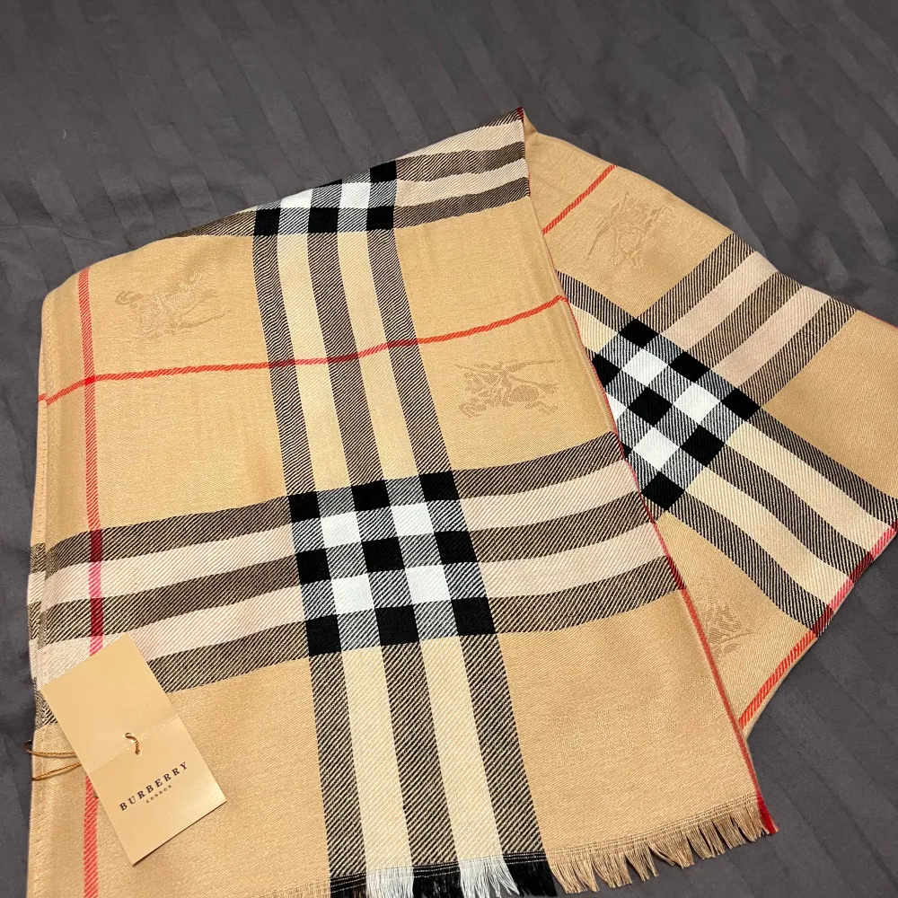 Säljer en klassisk rutig halsduk från Burberry i beige⭐️Den har ett stilrent mönster och passar till det mesta. Halsduken är i nytt skick och kommer med originalförpackning. Perfekt för höst och vinter!🍂❄️. Accessoarer.