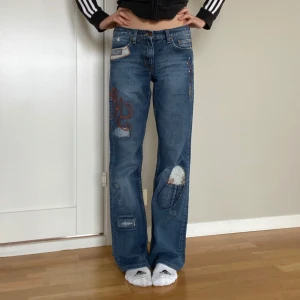 Hilfiger denim lowwaist bootcut  - ett par supercoola blå jeans från Hilfiger denim med broderade detaljer och patchar! innerbenslängd 78 cm och midjemått tvärs över runt 39 cm 💞 skriv vid övriga frågor och funderingar, pris kan diskuteras vid snabb affär