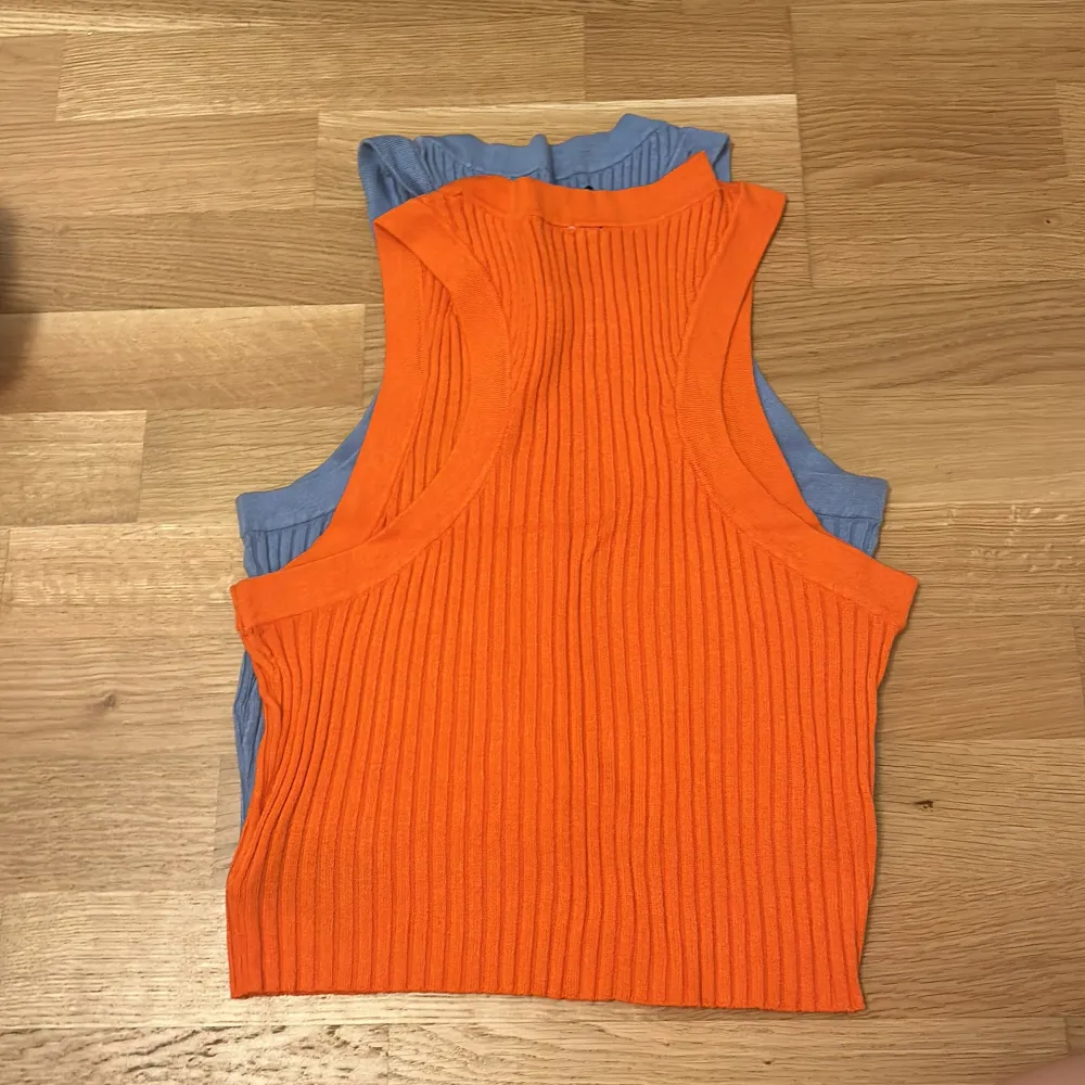 Säljer två ribbade ärmlösa toppar från H&M Divided i storlek S (1 för 80kr 2 för 50kr). En i ljusblå och en i orange, perfekta för sommaren. De är croppade och har en tight passform, vilket gör dem supertrendiga och bekväma. Perfekta för en avslappnad dag eller en utekväll!. Toppar.