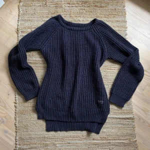 Svart stickad tröja från HMND - Säljer en snygg och bekväm svart stickad tröja från HMND. Perfekt för kyliga dagar med sin tjocka och mysiga kvalitet. Tröjan har långa ärmar och en klassisk rund halsringning. Passar både till vardags och lite finare tillfällen. 💙