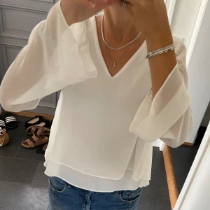 Vit volangblus  - Vit volangblus i två lager från KappAhl i storlek 38. Fint skick. Använd gärna köp nu!