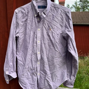 Ralph Lauren skjorta  - Rosa Ralph Lauren skjorta | skick 7/10 (ostruken), liten i storleken men annars inga defekter | storlek M (passar S/XS) | pris: 199kr | Fraktar via PostNord och Instabox på köparens bekostnad | Hör av dig vid frågor och funderingar mvh 