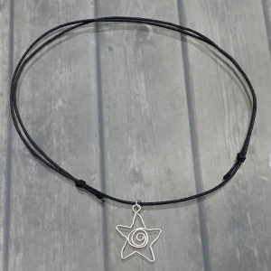Stjärnhalsband - Gjort av mig på silvrig smyckestråd och konstläder. Justerbart. Berlocken är ca 2,5cm. Kontakta gärna mig vid frågor!