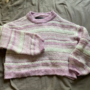 Stickad tröja  - En jättemysig stickad tröja med ganska stora hål och fina färger!! Använd kanske en eller två gånger, puffiga ärmar.