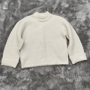 Vit stickad tröja från 157 - Säljer en supermysig vit stickad tröja från märket Lager 157. Den har en hög krage och långa ärmar med uppvikta muddar. Perfekt för kalla höst- och vinterdagar. Tröjan är i bra skick och väldigt bekväm att ha på sig. Passar perfekt till både jeans och kjol!