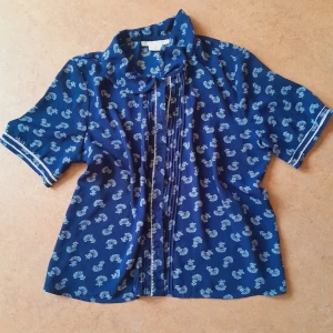 Söt Blus - En mörkblå blus med vita detaljer, jättesöt. Knappar fram. Den är i mesh-aktigt tyg men inte genomskinlig. Storlek S och i mycket fint skick. 