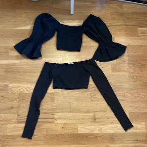 Två svarta magtröjor med ärmar  - Två svarta magtröjor med ärmar, ena med puffärmar 