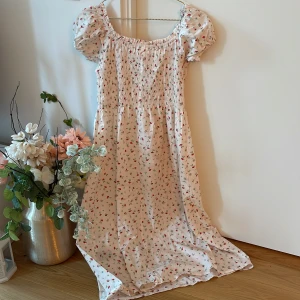 Söt sommarklänning - Säljer denna söta sommarklänning från H&M. Offwhite med röda små blommor. Använt endast 1 gång. 