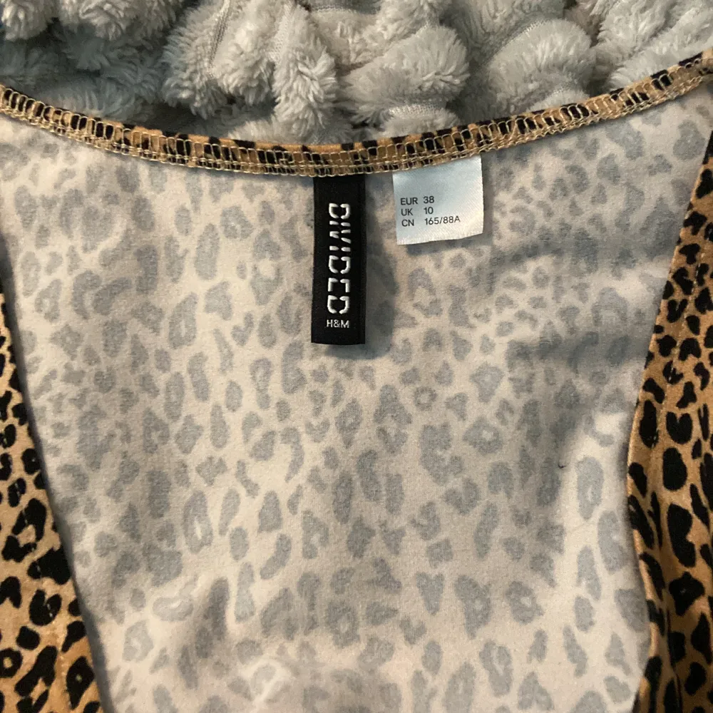 Säljer en superfin leopardmönstrad omlottklänning från H&M:s Divided-kollektion. Klänningen är kortärmad och har en knytning i midjan som ger en snygg passform. Perfekt för en fest eller en utekväll! 🐆. Klänningar.