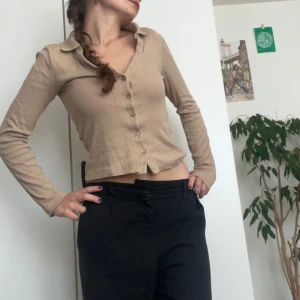 Beige croppad tröja från Bik Bok - Säljer en superfin beige croppad tröja från Bik Bok. Den har långa ärmar och knappar framtill. Perfekt för både vardag och fest! Tröjan är i nyskick och väldigt bekväm att ha på sig. Passar perfekt till höst och vår.