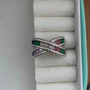 Snygg ny ring - Utsökt ring med flera kristaller i olika färger, storlek 17 med silverplätering. Ny och okänt märke.