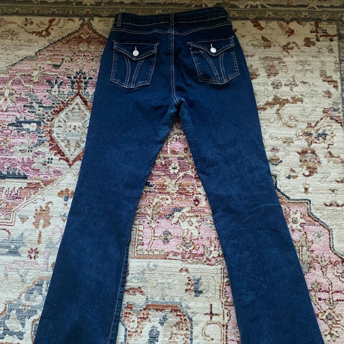 Low bootcut jeans med knappar på backfickan  - 90