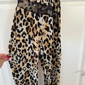 Leopardmönstrade byxor från Fou de Filles - Säljer en snygg leopardmönstrad bodysuit med långa och som har korta ärmar likt ett linna upptill, fler bilder finns för intresserade💌🫶🏼
