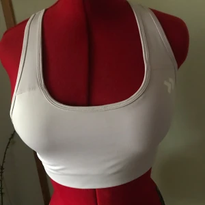 Vit sportig linnetopp - Säljer en vit sportig linnetopp från Lager 157 i mycket bra skick. Perfekt för träning eller sommaraktiviteter. Den ärmlösa designen och det stretchiga materialet ger en bekväm passform. Toppen har en enkel och stilren look med ett litet tryck på sidan.