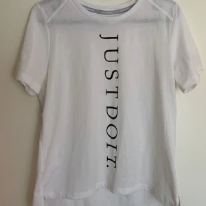 Vit Dri-Fit t-shirt från Nike - Dri-Fit t-shirt från Nike med texten 'JUST DO IT'  lätta och andningsbara material. 