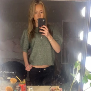 Grön stickad tröja - Säljer en superfin grön stickad tröja med korta ärmar. Den är  perfekt för både vår och sommar. Tröjan har en avslappnad passform och är riktigt skön att ha på sig. Perfekt för en casual look! 💚