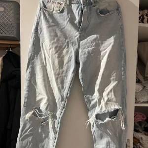 Ljusa jeans med slitningar - Säljer ett par ljusa jeans från Perfect Jeans i storlek 34. De har en cool, sliten look med hål vid knäna och en klassisk femficksdesign. Perfekta för en avslappnad stil! 🕶️