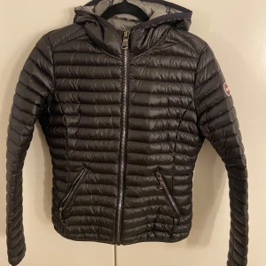 Svart dunjacka från Colmar - Säljer en snygg svart dunjacka från Colmar i mycket bra skick. Jackan har en dragkedja framtill och två praktiska fickor med dragkedjor. Perfekt för höst och vinter, håller dig varm och stilren. Storleken är dam S och passformen är normal. Huvan ger extra skydd mot kyla och vind. Köpt 1 år sedan, ej kvitto❤️