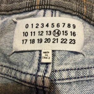 Ljusblå jeans från Maison Margiela - Säljer ett par snygga ljusblå jeans från Maison Margiela från 2004. De har en unik design med mörkare bakfickor och är tillverkade i Italien. Perfekta för både vardag och fest! 🕺