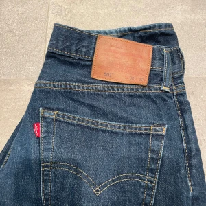 Levi's 501 Jeans - Säljer ett par klassiska Levi's 501 jeans i mörkblå denim. De är i mycket bra skick och har den ikoniska raka passformen. Storlek 30/32. Skriv vid funderingar