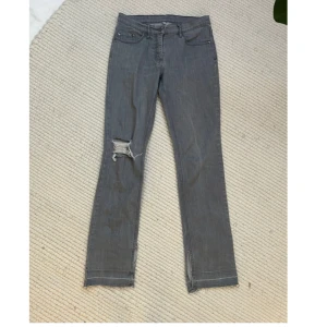 Grå jeans med slitningar - Säljer ett par grå jeans med coola slitningar på ena benet. Jag har själv klippt en slits på vardera ben på innersidan. 