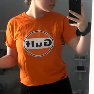 Orange t-shirt med Gulf-logga - Säljer en retro orange t-shirt den klassiska Gulf-loggan på framsidan. Storlek S. 