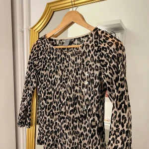 Leopardmönstrad kofta - Säljer en snygg leopardmönstrad kofta med trekvartsärm. Perfekt för att ge din outfit en vild touch! Koftan är i bra skick och passar både till vardags och fest. 🐆✨