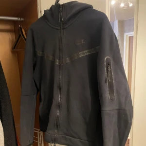 Nike tech fleece  - Svart Nike tech fleece i sådär skick, den har några små hål och ett litet hål i högerfickan, men inget som förstör vardaglig användning 
